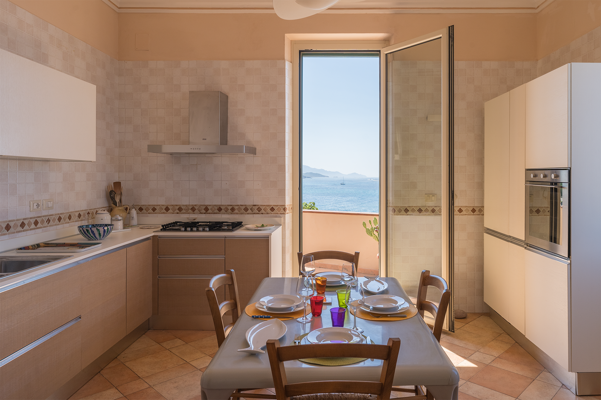Cucina attrezzata con vista mare Cucina attrezzata con zona pranzo e porta finestra affacciata sul mare di Alghero