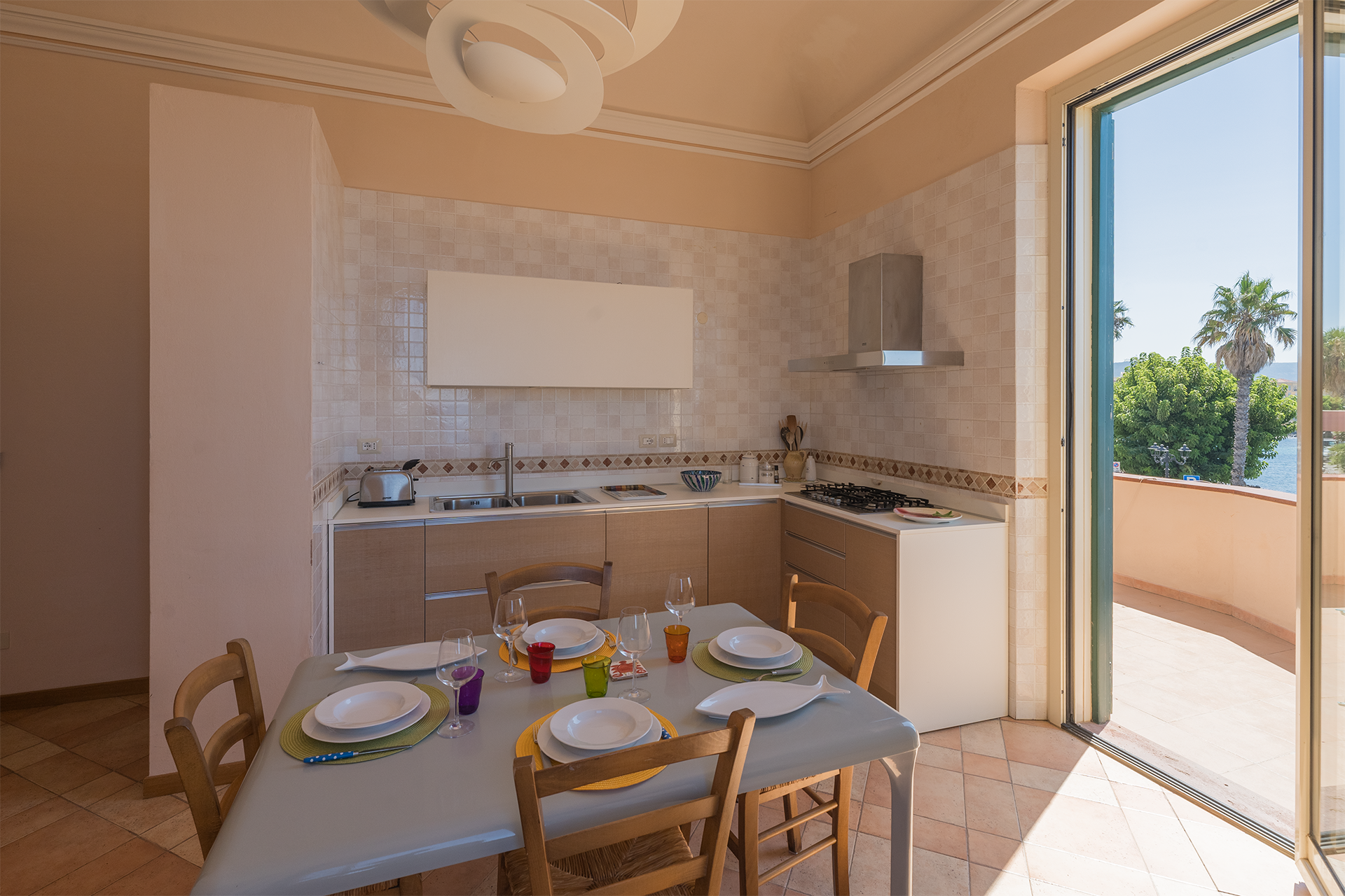Zona pranzo collegata alla terrazza Zona pranzo e cucina moderna con porta aperta sulla terrazza dell’appartamento Le Viste