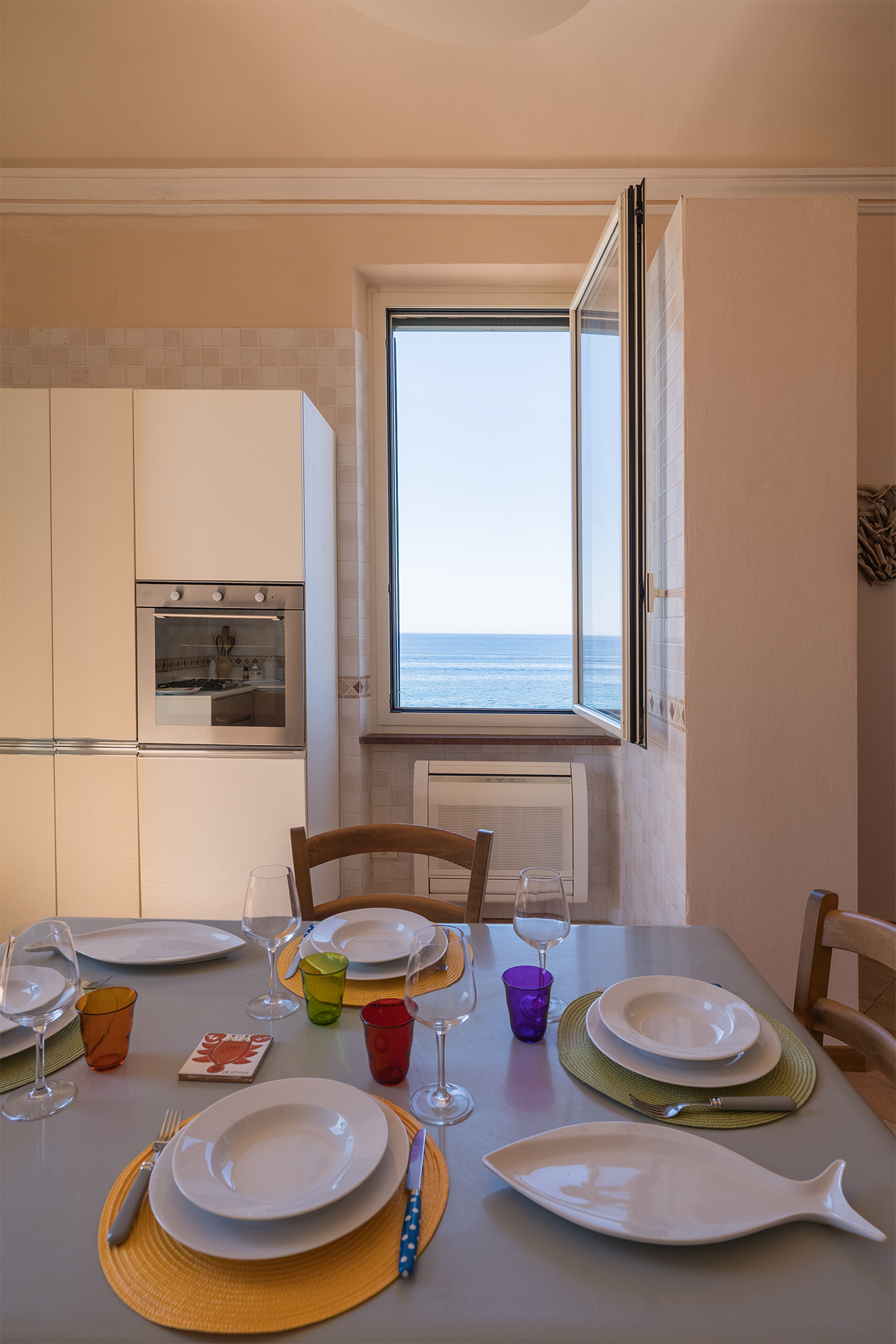 Tavolo da pranzo davanti al mare Tavolo da pranzo apparecchiato davanti alla finestra vista mare nell’appartamento Le Viste