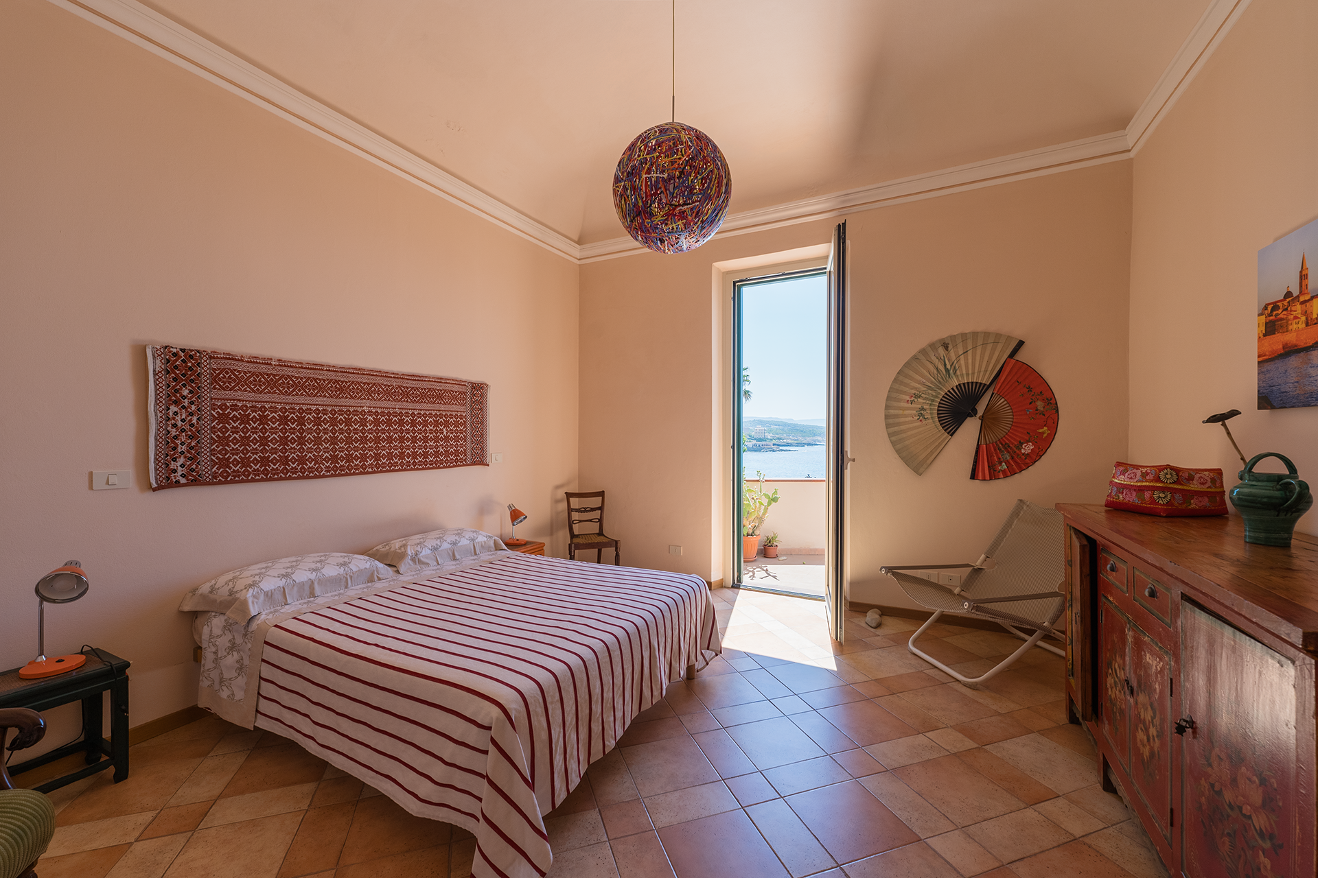 Camera matrimoniale con terrazza vista mare Camera matrimoniale spaziosa con letto, arredi colorati e terrazza vista mare ad Alghero