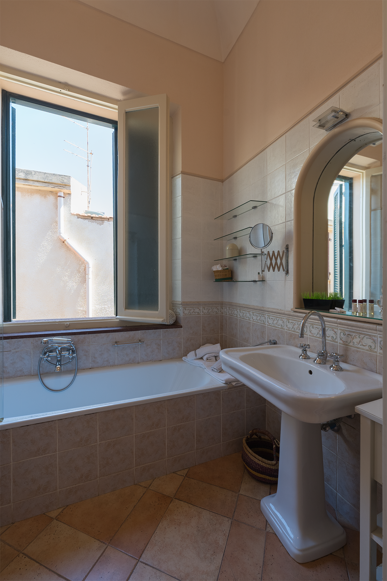 Bagno con vasca e luce naturale Bagno luminoso con vasca, lavabo e finestra nell’appartamento Le Viste ad Alghero