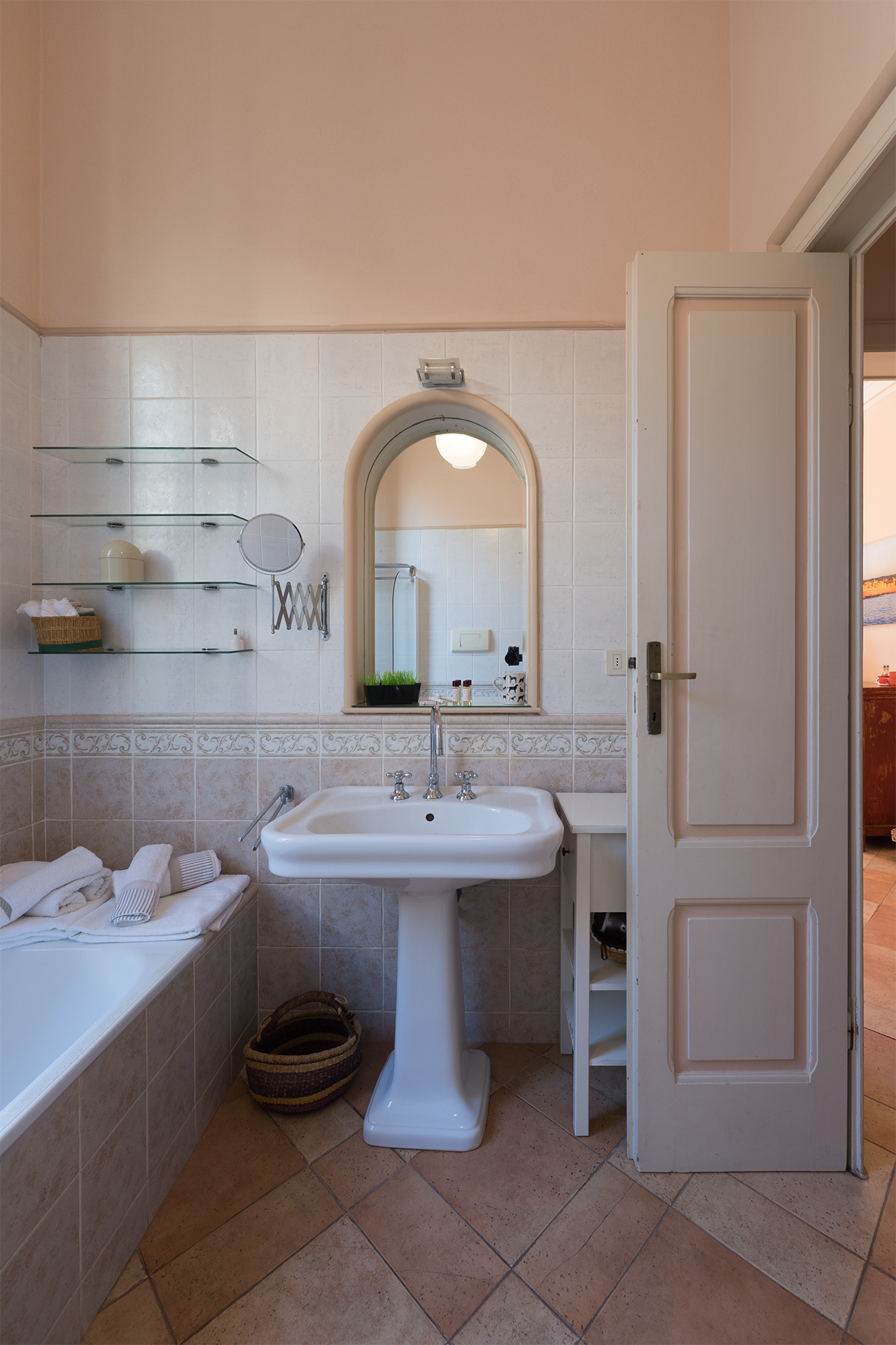 Lavabo e zona cortesia del bagno Lavabo con specchio, mensole e set di cortesia nel bagno dell’appartamento Le Viste