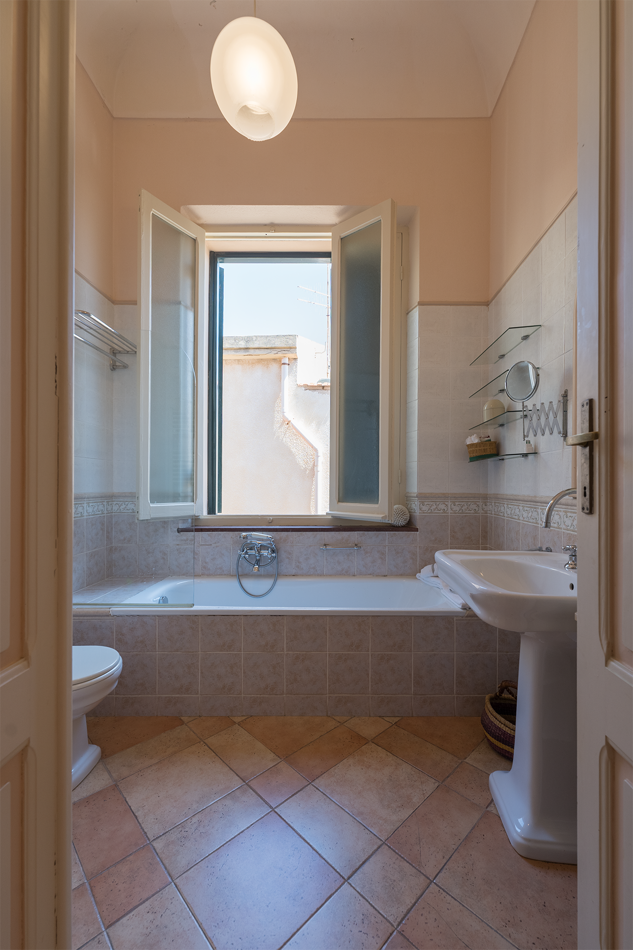 Vista completa del bagno Vista completa del bagno con vasca, finestra e lavabo nell’appartamento Le Viste