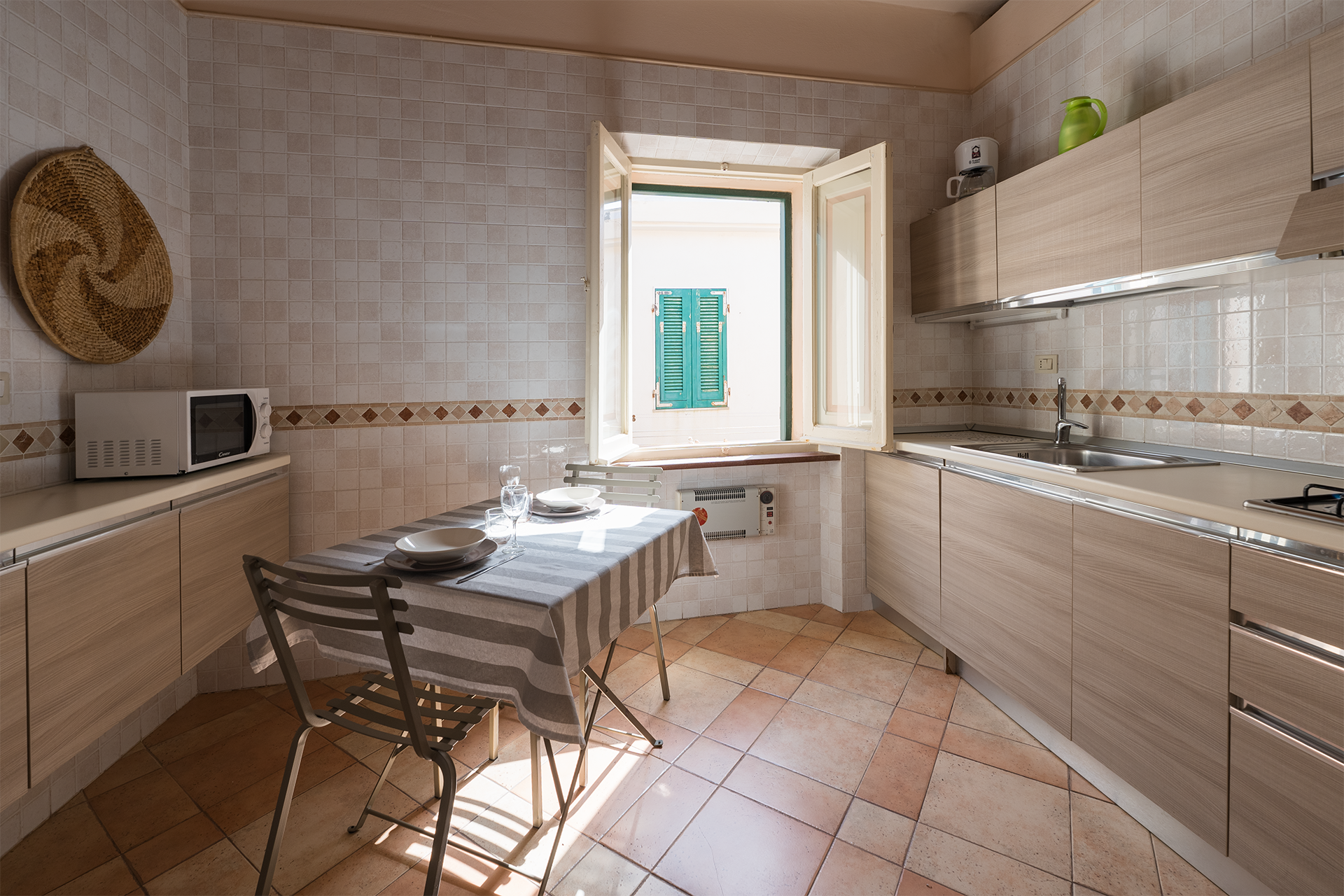 Cucina con zona pranzo – L’Attichetto Cucina attrezzata con tavolo da pranzo e finestra nell’appartamento L’Attichetto ad Alghero