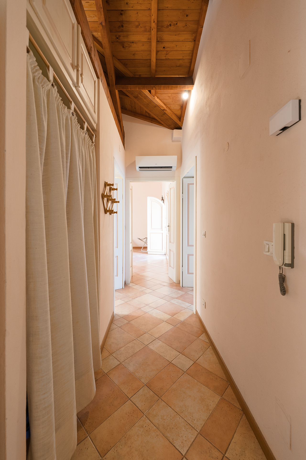 Corridoio con travi in legno Corridoio interno con soffitto in legno e aria condizionata nell’appartamento L’Attichetto