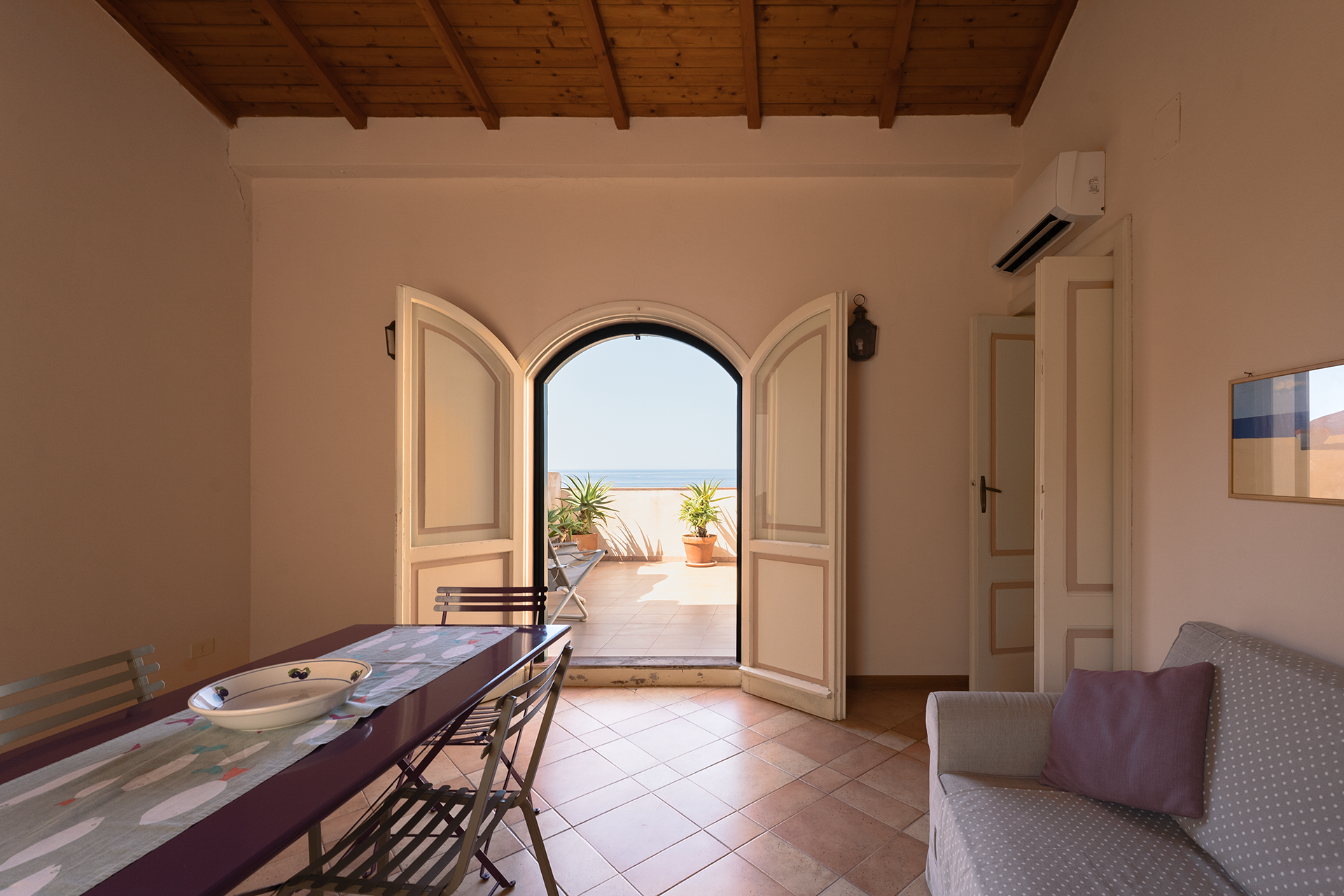 Soggiorno affacciato sulla terrazza Soggiorno con porta ad arco e terrazza panoramica vista mare a L’Attichetto